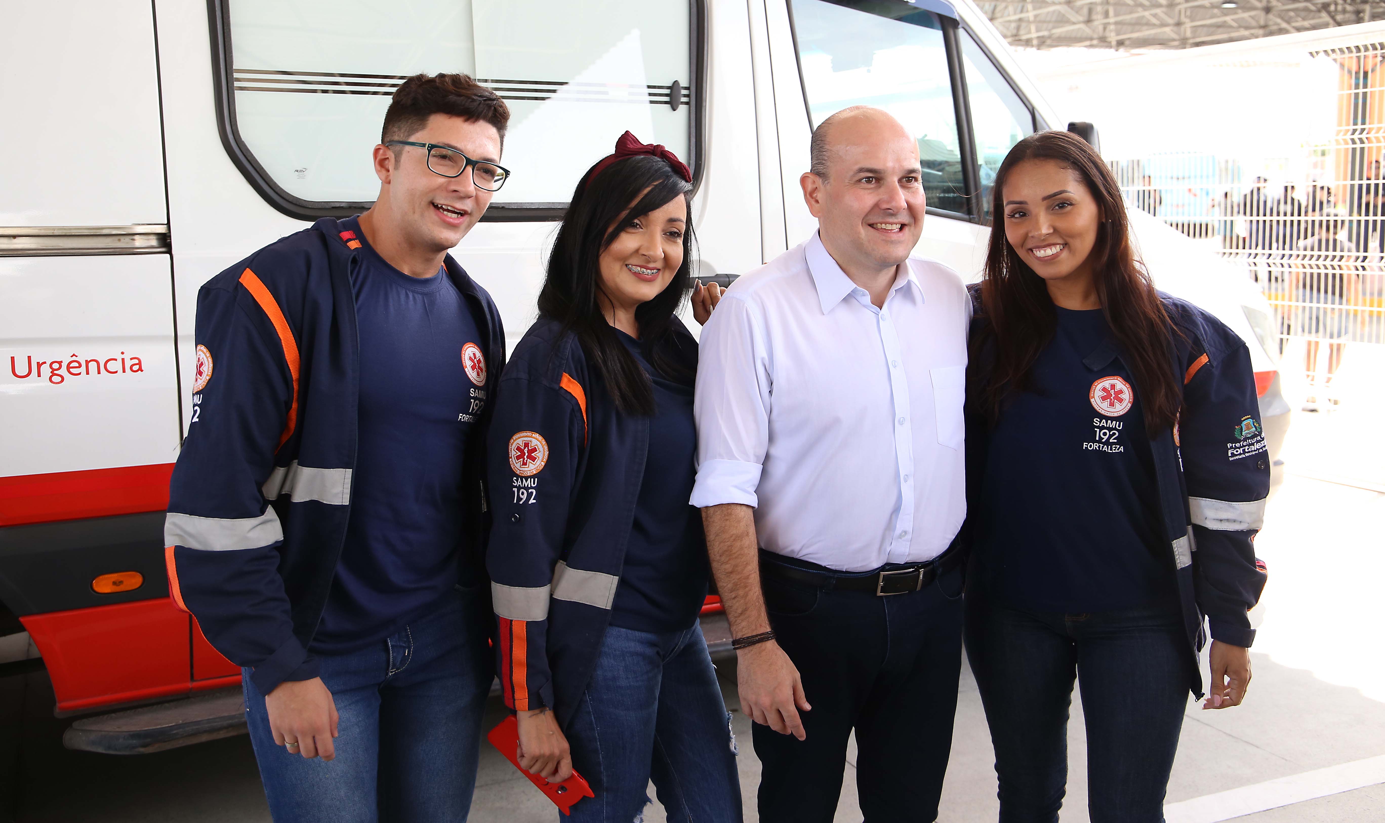 grupo de pessoas na frente de uma ambulância